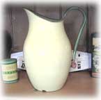 A large green and cream enamelware jug.