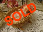 German bisque baby doll in cot.